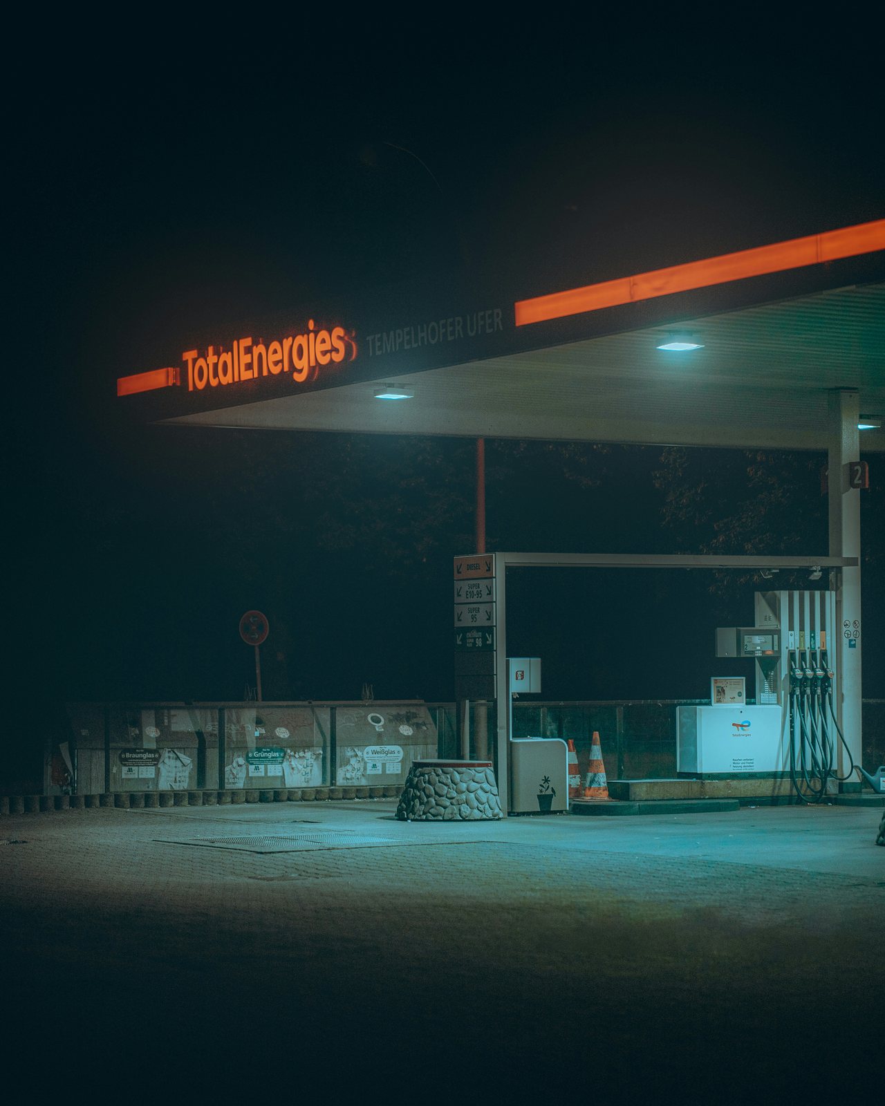 A lit fuel station at night, a rider's resupply lifeline